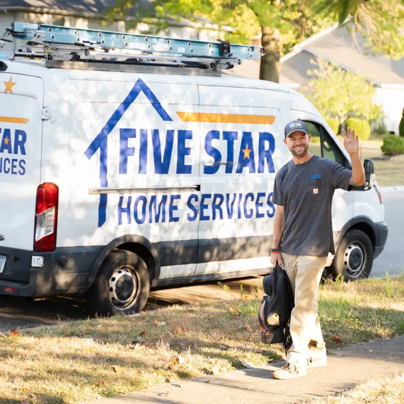 Plumber with tools waving in front of a Five Star Home Services Van