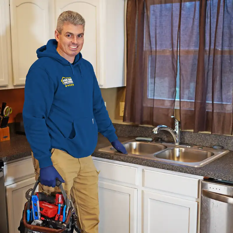 plumber standing next to a kitchen sink