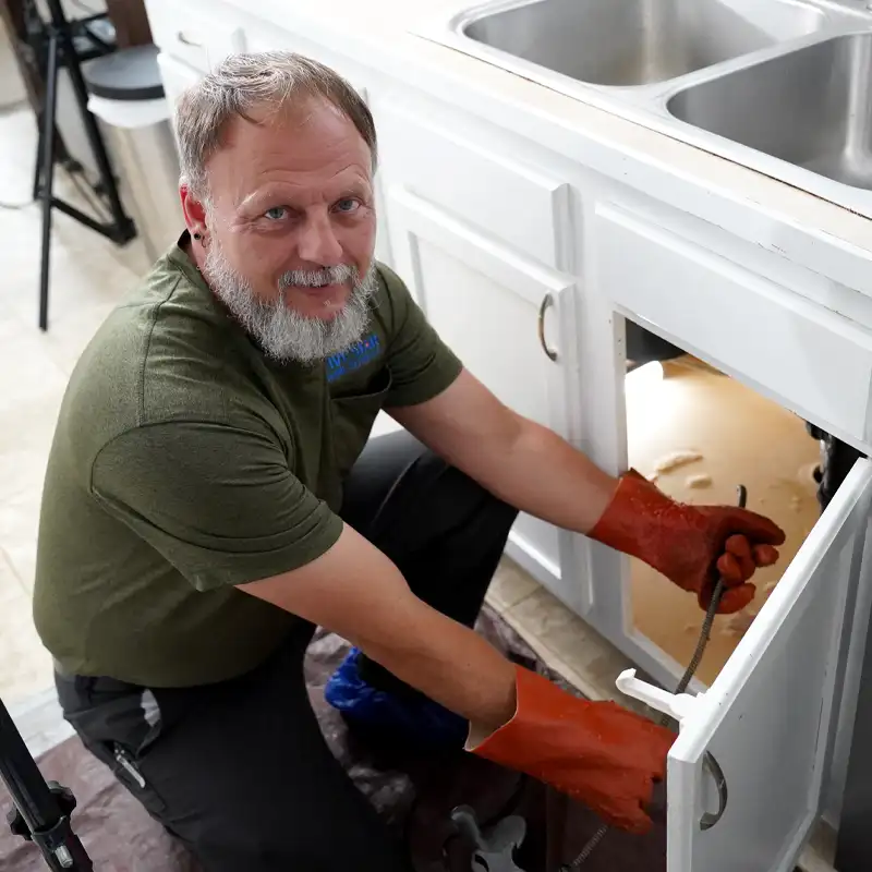 Plumber installing a garbage disposal