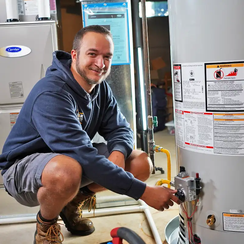 Plumber kneeling next to a hot water heater