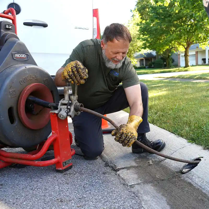 Plumber working on a sewer line with a video camara inspection unit