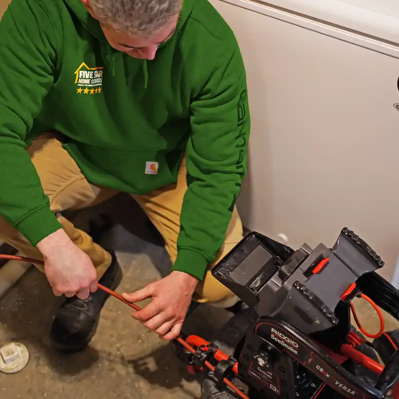 Plumber using video inspection equipment